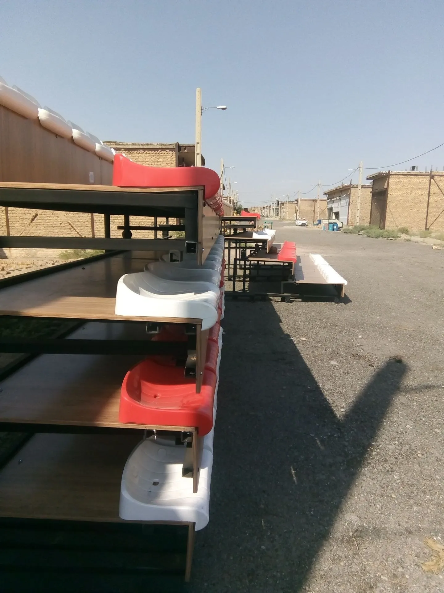 نیمکت فوتبال، نمای جانبی سکوی چندردیفه با صندلی‌های قرمز و سفید